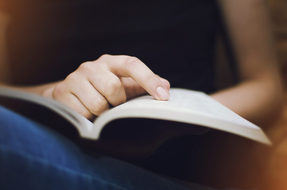 Finger pointing to an open book