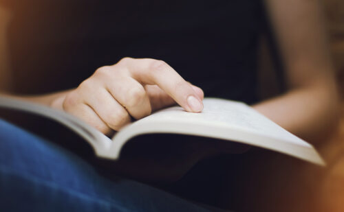 Finger pointing to an open book