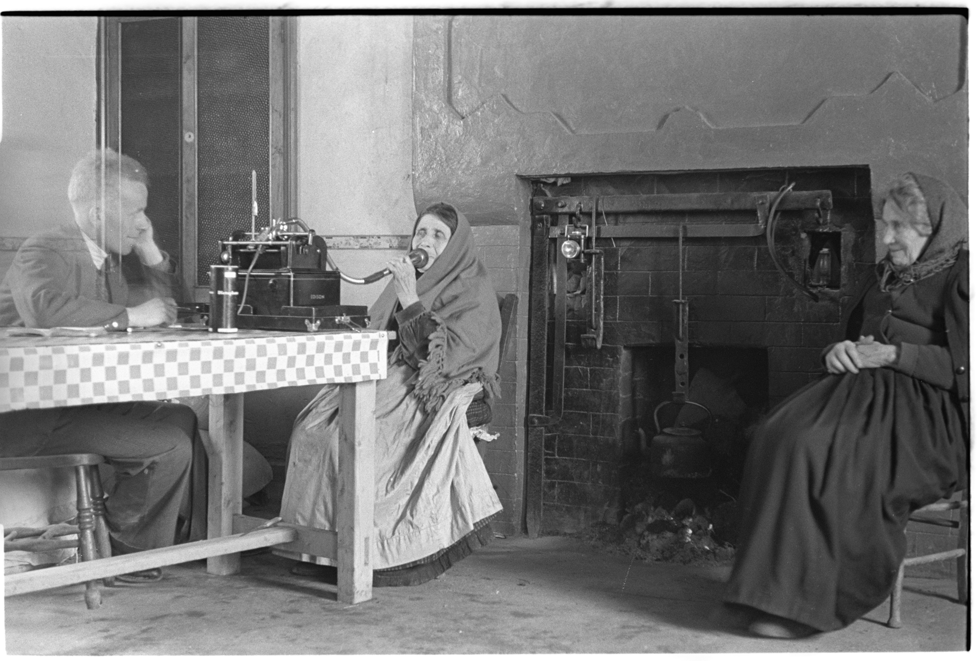 Gaelic speaker pictured speaking into a Folklore Commission recorder.
