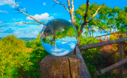 Image of nature landscape with glass sphere inverting image, title called new perspective