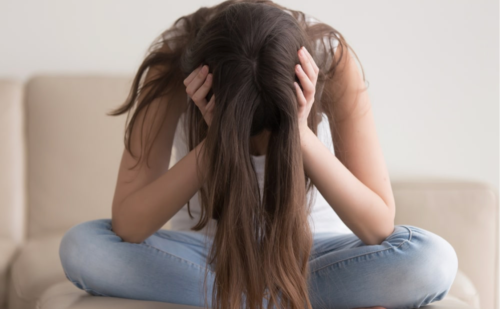 An of girl with head in hands